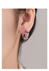 Détail de créoles en argent S925 serties de pierres multicolores portées par un mannequin
