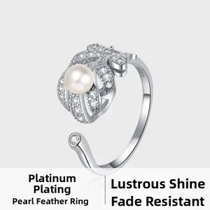 Macro detail of S925 sterling silver feather ring with pearl and micro-pave crystals
