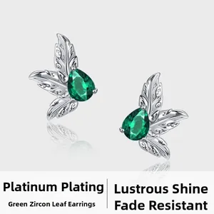 Detail view of platinum plated leaf earrings with green zircon water drop stones