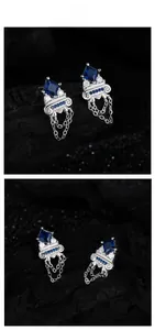Macro shot of S925 silver fringe earrings with blue zircon on black stone texture