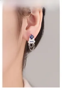 Detail of S925 silver earring with blue zircon and elegant chain tassel on ear