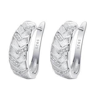 Gros plan de boucles d'oreilles en argent S925 avec textures et zircons brillants