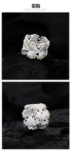 Macro shot of silver brushed ginkgo leaf ring with gold edges on black rock