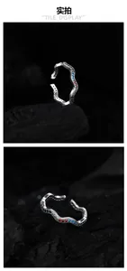 Detail of 925 silver wave ring showing colorful gemstones on dark charcoal background