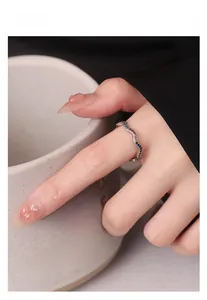 Detail of 925 sterling silver wave ring featuring colorful crystals on a model hand