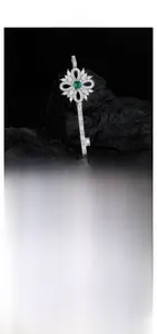 Détail macro du pendentif clé en argent avec zircon et pierre précieuse verte