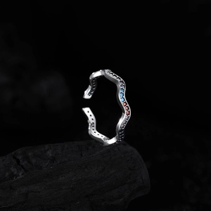 925 sterling silver wave ring with colorful gemstones on a black textured stone base