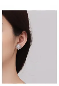 Détail d'une boucle d'oreille trèfle en argent avec nacre blanche en gros plan