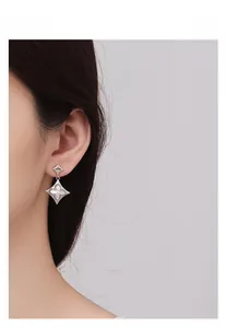 Close-up of S925 silver four-leaf clover earrings with white shell inlay on model
