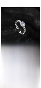 Macro shot of S925 silver ring featuring square purple gem and chain link detail
