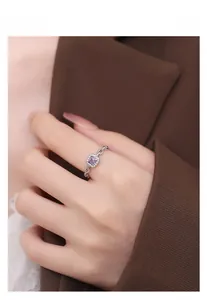 Detail of S925 silver ring with purple square stone and hollow chain band on finger