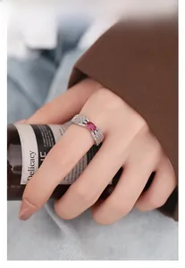 Detailed view of an S925 silver leaf ring with pink gemstone on a female finger