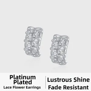 Gros plan de boucles d'oreilles en dentelle d'argent avec placage en or blanc et cristaux