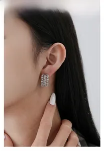Gros plan de boucles d'oreilles en argent S925 avec dentelle évidée et zircons sur un mannequin