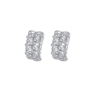 Détail macro de créoles en argent S925 avec motif de fleurs évidées en dentelle