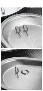 Macro detail of vintage S925 sterling silver hoop earrings with embossed vine pattern