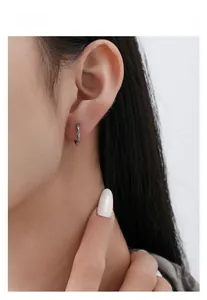 Detail of vintage S925 silver hoop earring with ethnic texture worn by a model