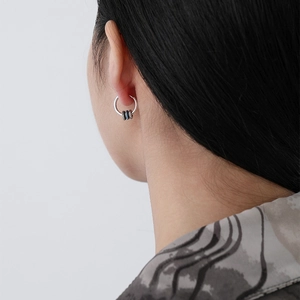 Silver S925 sterling silver hoop earrings with blue zircon beads worn by a female model