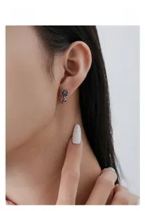 Gros plan de boucles d'oreilles rose en argent S925 vintage portées pour un style gothique