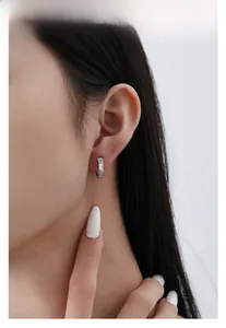 Detailed view of S925 silver hoop earring with white shell inlay and crystals on ear