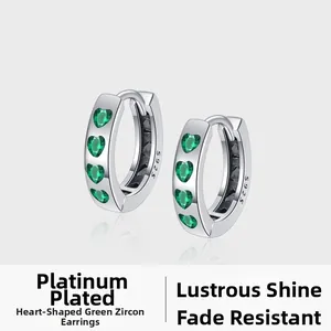 Close-up of S925 sterling silver hoop earrings featuring heart-shaped green zircon stones