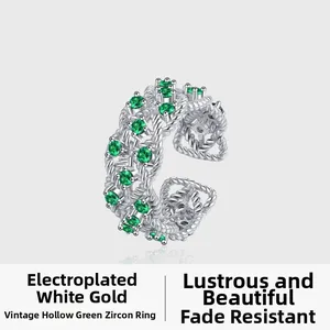 Detailed close-up of vintage hollow silver ring with green zircon and twisted texture