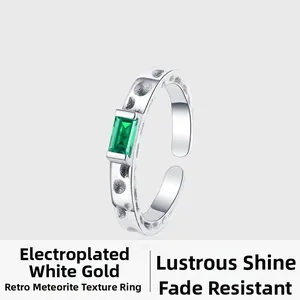 Detailed macro view of an S925 silver ring featuring emerald-cut green gemstone and crater texture