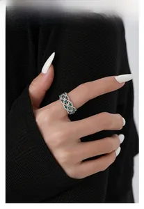 Close-up of vintage S925 silver ring featuring green zircon stones and woven hollow design