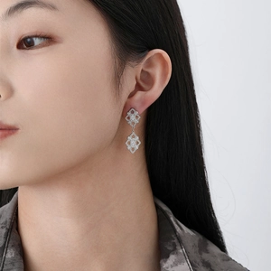 Orecchini pendenti vintage in argento S925 traforato indossati da una modella elegante