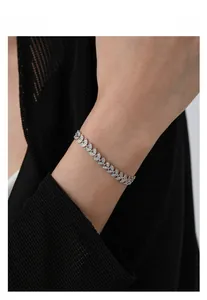 Detailed view of silver wheat leaf bracelet with micro-pave crystals on a model wrist