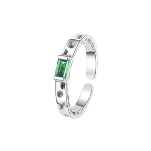 Macro detail of square emerald stone on silver ring with textured meteorite surface
