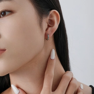 Minimalist S925 sterling silver hoop earrings with green heart zirconia on a female model