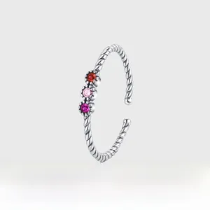 Detail of twisted silver band with three circular colorful zircon stones in platinum plating