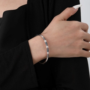 Macro view of S925 silver bracelet featuring colorful zircon cylinder charms on wrist