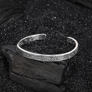 Dettaglio ravvicinato del bracciale in argento retrò con motivi a rilievo su pietre nere