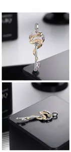 Détail du pendentif clé serpent en argent S925 avec accents dorés et gemmes colorées