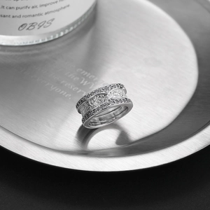 Macro view of wide silver ring with double row of diamonds and etched rock texture detail