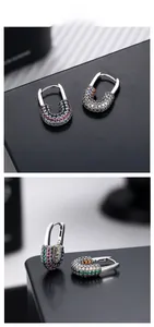 Macro shot of silver safety pin earrings with colorful micro-pave zircon gemstones