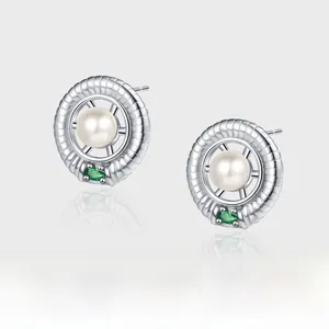 Detail of S925 silver geometric stud earrings with white pearl and green emerald gemstone