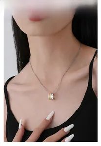 Close-up of S925 sterling silver cylinder pendant with gold accents and sparkling stones