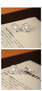 Detail of S925 silver pearl stud earring with emerald accent and textured frame