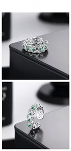 Detailed view of S925 silver ring with emerald zircon weaving pattern and open design