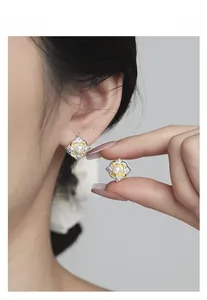 Detailed close-up of vintage flower pearl earrings in silver and gold contrast finish