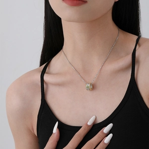 S925 sterling silver clover pendant with green zircon and gold accents on model