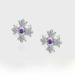 Macro detail of S925 silver cross earrings featuring purple zircon and white pearls