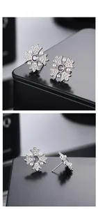 Detailed macro view of S925 silver cross earrings with purple zircon and white pearls
