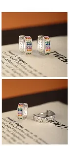 Vue macro des boucles d'oreilles arc-en-ciel en argent avec pierres et détails de fleurs