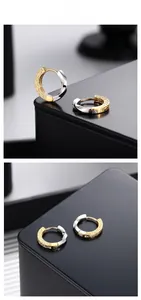 Macro shot of S925 silver Mobius earrings with dual-tone gold plating and floral engraving