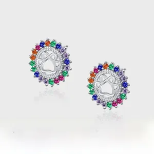 Macro view of S925 silver stud earrings with rainbow crystal halo and pet paw design