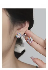 Macro detail of S925 silver paw stud earrings featuring vibrant rainbow crystal inlay